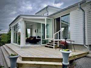 a house with a wooden deck with a living room at Casa de la Curva in Båstad