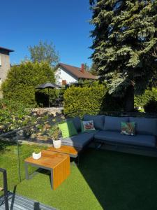 a blue couch and a coffee table in a yard at Apartamenty Okrętowa 23 Bolek Lolek in Bielsko-Biala
