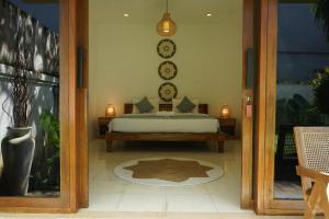1 dormitorio con 1 cama en una habitación con puerta en Tattva Uluwatu, Surf & Yoga Retreat, en Jimbaran 82 fotos más