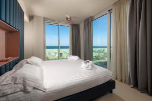 a bedroom with a bed with a view of the ocean at Mercure Hotel Rimini Artis in Rimini +97 photos