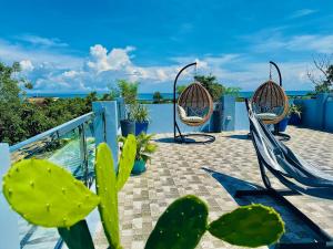 a patio with chairs and a view of the ocean at La'Cris Homestay in Ocoy