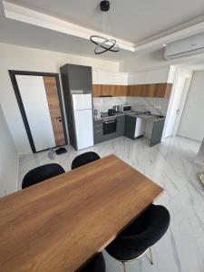 a kitchen with a wooden table and black chairs at Riverside Life Residence in Iskele