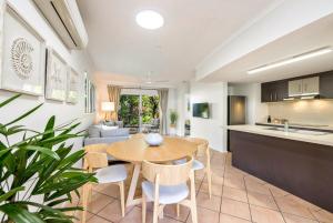 a kitchen and living room with a table and chairs at Trinity Escape - Marlin Cove Resort - Trinity Beach in Trinity Beach
