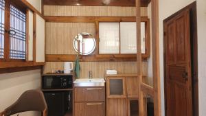 a small kitchen with a sink and a mirror at HAEMIL Hanok 해밀한옥 in Seoul
