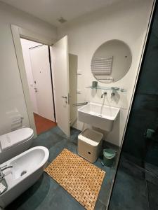 a bathroom with a sink and a toilet and a mirror at La Suite del Doge - Parking in Treviso