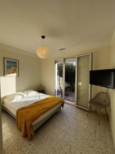 ein Schlafzimmer mit einem Bett und einem Flachbildfernseher in der Unterkunft Maison T4 plain pied climatisée avec une belle terrasse ombragée 6AVR44 in Canet-en-Roussillon