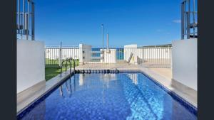 a large swimming pool in front of a building at The Manly beach pad in Sydney