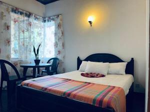a bedroom with a bed and a table with a tableasonable at Mystique Hideout in Kandy