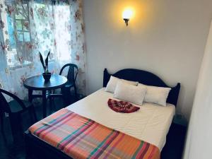 a small bedroom with a bed with a table and a table at Mystique Hideout in Kandy