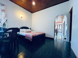 a bedroom with a bed and a table and a chair at Mystique Hideout in Kandy +37 photos