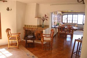 a living room with a fireplace and a table and chairs at cave house with sea views in Santa Susanna