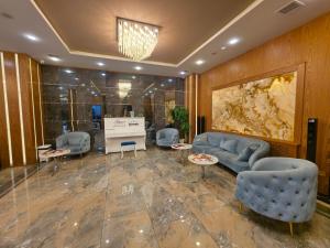 vestíbulo con sofá, sillas y piano en Regal Hotel Baku, en Baku