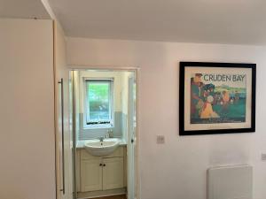 a bathroom with a sink and a picture on the wall at Studio Close to Excel Centre in London +11 photos