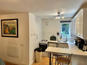 a kitchen with a sink and a stove top oven at Studio Close to Excel Centre in London