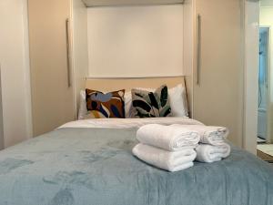 a bedroom with a bed with towels on it at Studio Close to Excel Centre in London