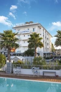 a hotel with a swimming pool in front of a building at Hotel Ca' Bianca in Riccione