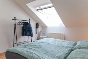 a bedroom with a bed in a white room at Schöne Wohnung mit Parkplatz im Zentrum von Linz in Linz
