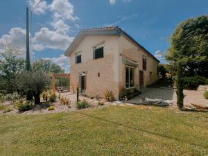an old brick house with a grass yard at La Maison Des Pierres Blondes in Orban