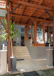 a house with wooden ceilings and a potted plant at Kipos Resort in Nea Peramos