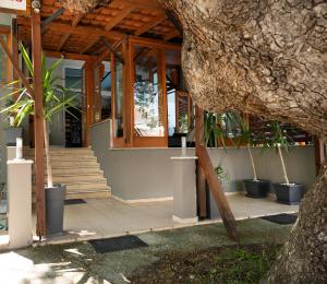 a building with a wooden roof and some plants at Kipos Resort in Nea Peramos