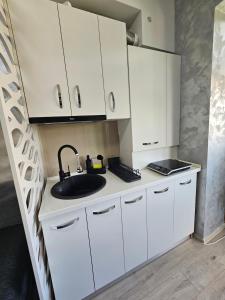 a kitchen with white cabinets and a sink at Modern Studio 4 in Onești +11 photos