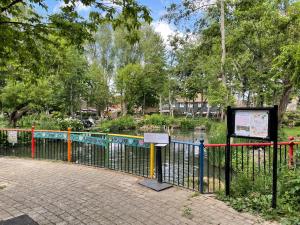 a fence with a sign next to a pond at Studio Close to Excel Centre in London