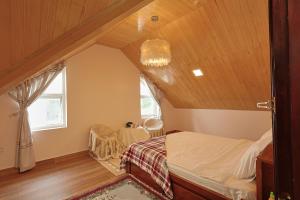 une chambre mansardée avec un lit et une fenêtre dans l'établissement The Hill Villa - Đà Lạt, à Xuan An