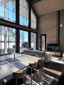 a living room with a large table and chairs at Villa Norvahovi - Lake view, sauna and wood interior in Rovaniemi