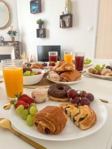 a table topped with plates of pastries and fruit at Le Refuge, Pet friendly, Free Parking in Pagny-sur-Moselle