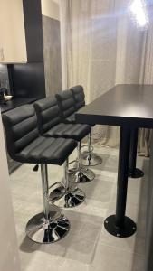 a barber shop with black leather chairs and a table at Elegant and spacious penthouse in Mesochórion