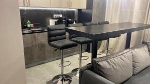 a kitchen with a black table and bar stools at Elegant and spacious penthouse in Mesochórion