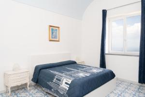 a white bedroom with a bed and a window at Villa Alba - Rubino in Amalfi
