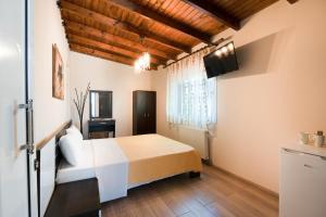 a bedroom with a white bed and a window at Kipos Resort in Nea Peramos