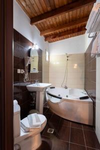 a bathroom with a tub and a sink at Kipos Resort in Nea Peramos