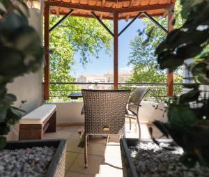 a patio with two chairs and a pergola at Kipos Resort in Nea Peramos