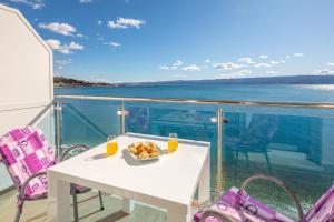 einen weißen Tisch mit einer Obstschale auf dem Balkon in der Unterkunft Blue Wonder Apartments in Dugi Rat + 38 Fotos