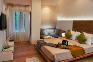 Un dormitorio con una cama grande con almohadas verdes. en PARK SIGNATURE HOTELS - Royal Benza, en Vijayawāda