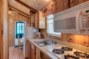 cocina con fregadero y nevera en Lake Conroe One-Bedroom Cabin 3, en Willis