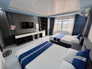 een hotelkamer met twee bedden en een tv bij New Way Hotel in Cat Ba