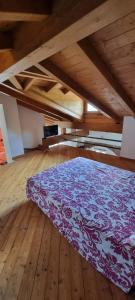 une chambre avec un lit violet dans une pièce avec du parquet dans l'établissement Ranalista, à Castelveccana