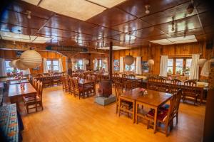 a dining room with wooden tables and chairs at Lukla Himalaya Lodge in Lukla