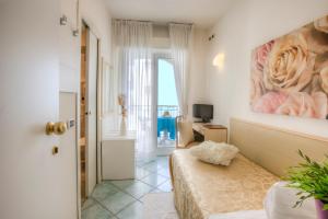a room with a couch and a painting on the wall at Hotel Ca' Bianca in Riccione