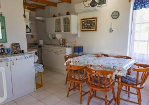 a kitchen with a table and some chairs and a table and a counter at Horgony Vendégház in Mezőtúr