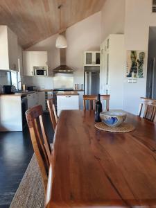 a kitchen and dining room with a wooden table at Valley Cottage, Treeton winery, Margaret River in Cowaramup