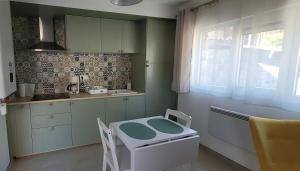 a kitchen with a table and a sink in it at Il Vialetto - Roma in Jeumont