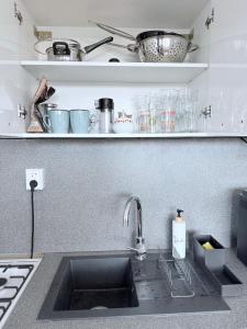 a kitchen with a sink and a counter top at Pohodlný apartmán Prievidza in Prievidza +7 photos