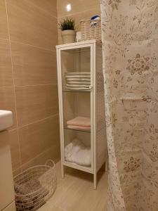 a bathroom with a white cabinet with towels at Apartamento turístico Aguere in Ribadesella