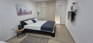 a bedroom with a bed and a television in it at Rooms Lanterna in Metajna