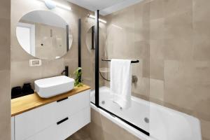 un bagno con un lavandino bianco e uno specchio di Ritzside Marina Stay a Herzliya B Altre 11 foto