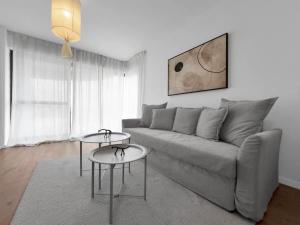 a living room with a gray couch and two tables at Ritzside Marina Stay in Herzliya B +11 photos